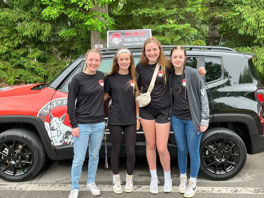The Lazy Dog crew by the branded delivery car